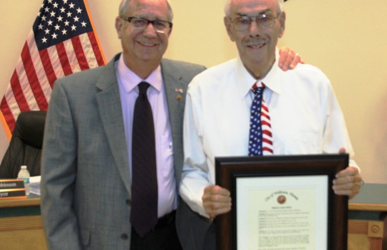 Williston Mayor Jerry Robinson presents Mayor Emeritus Gerald Hethcoat with a framed resolution celebrating his 31 years of public service to the city.