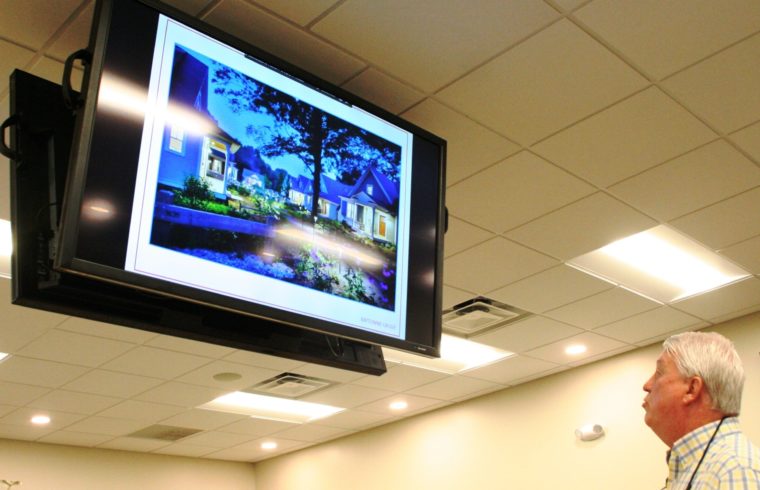 Johnny Sims, an engineer for Laurel Point Planned Development looks at an overhead screen showing a conceptual drawing of what the residential development would look like.