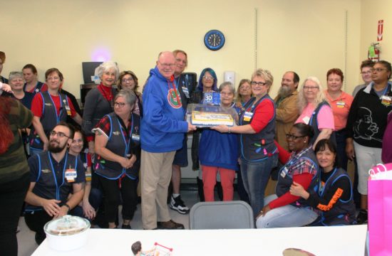 David Greene receives his retirement cake from People Lead Susie McKnight surrounded by his family of Wal-Mart co-workers.