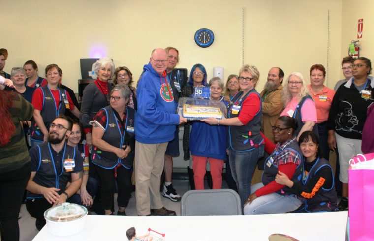 David Greene receives his retirement cake from People Lead Susie McKnight surrounded by his family of Wal-Mart co-workers.