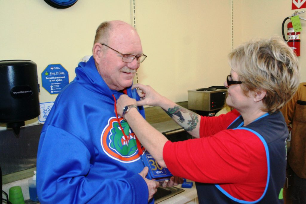 Retiring Wal-Mart employee David Greene receives his 30-year pin from People Lead Susie McKnight.