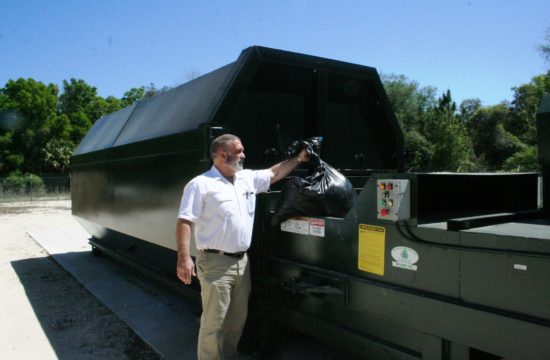 Landfill Administrative Director Rod Hastings demonstrates how residents drop their garbage in a compactor at 8 Mile Hill.