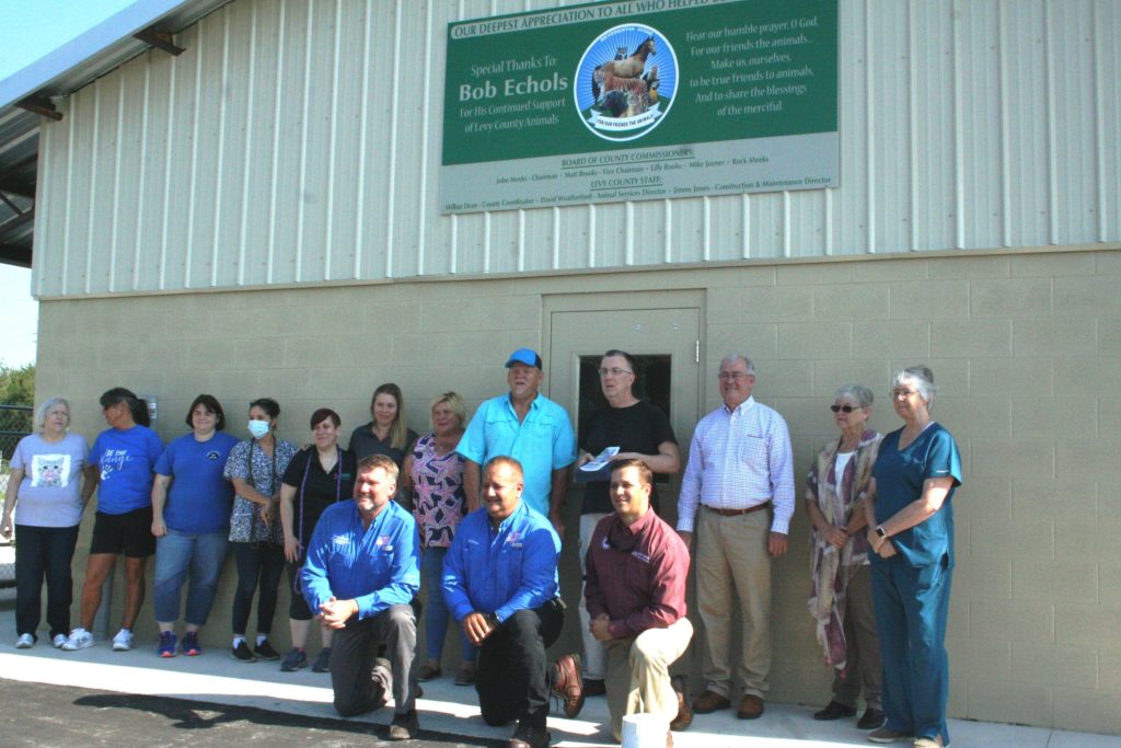 All of those involved in making the new facility a reality are pictured. In the front are County Commissioner John Meeks, County Maintenance and Construction Director Jimmy Jones and County Commission Chairman Matt Brooks. The seven ladies on the left represent animal rescue groups that work closely with animal services. The men next to them are Animal Services Director David Weatherford, Philanthropist Bob Echols, County Coordinator Wilbur Dean and next to him are Levy County Commissioner Lilly Rooks and Dr. Darlene Esler, animal services veterinarian.