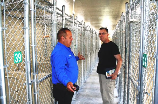 County Construction and Maintenance Manager Jimmy Jones, left, gives Bob Echols, the philanthropist who donated $290,000 to build the new county dog kennel, a tour of the facility after the dedication ceremony on June 17. Jones built the facility.