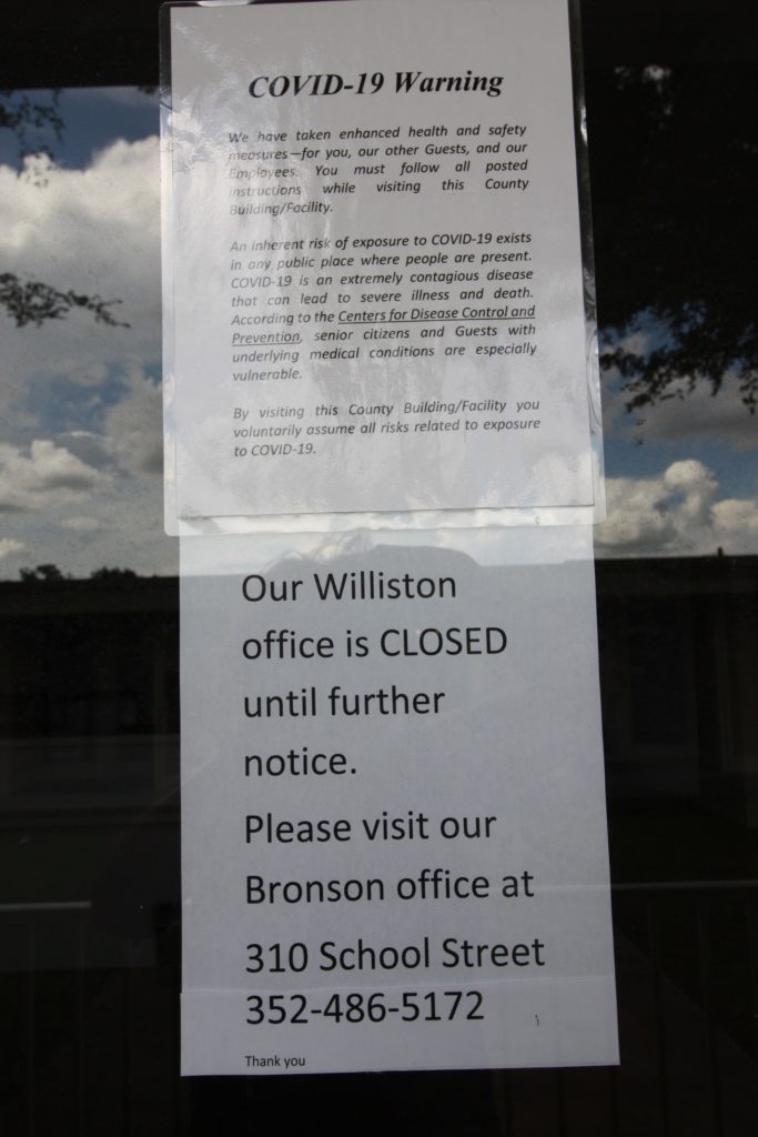 Photo by Linda Cooper: A notice on the front door of the Williston Tax Collector's office tells visitors the facility is closed until further notice. The same is true of the Chiefland tax office. COVID-19 was given as the reason for the closings.