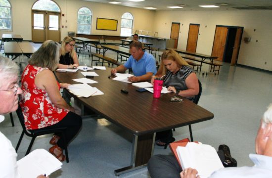 County Coordinator Wilbur Dean and County Labor Attorney Wayne Helsby chat during union negotiations Tuesday. Seated at the table on the left is County Human Resources Director Jacqueline Martin and at the end Alesha Rinaudo of the Department of Public Safety. On right are EMT Jimmy Jones and IAFF President Katy Graves.