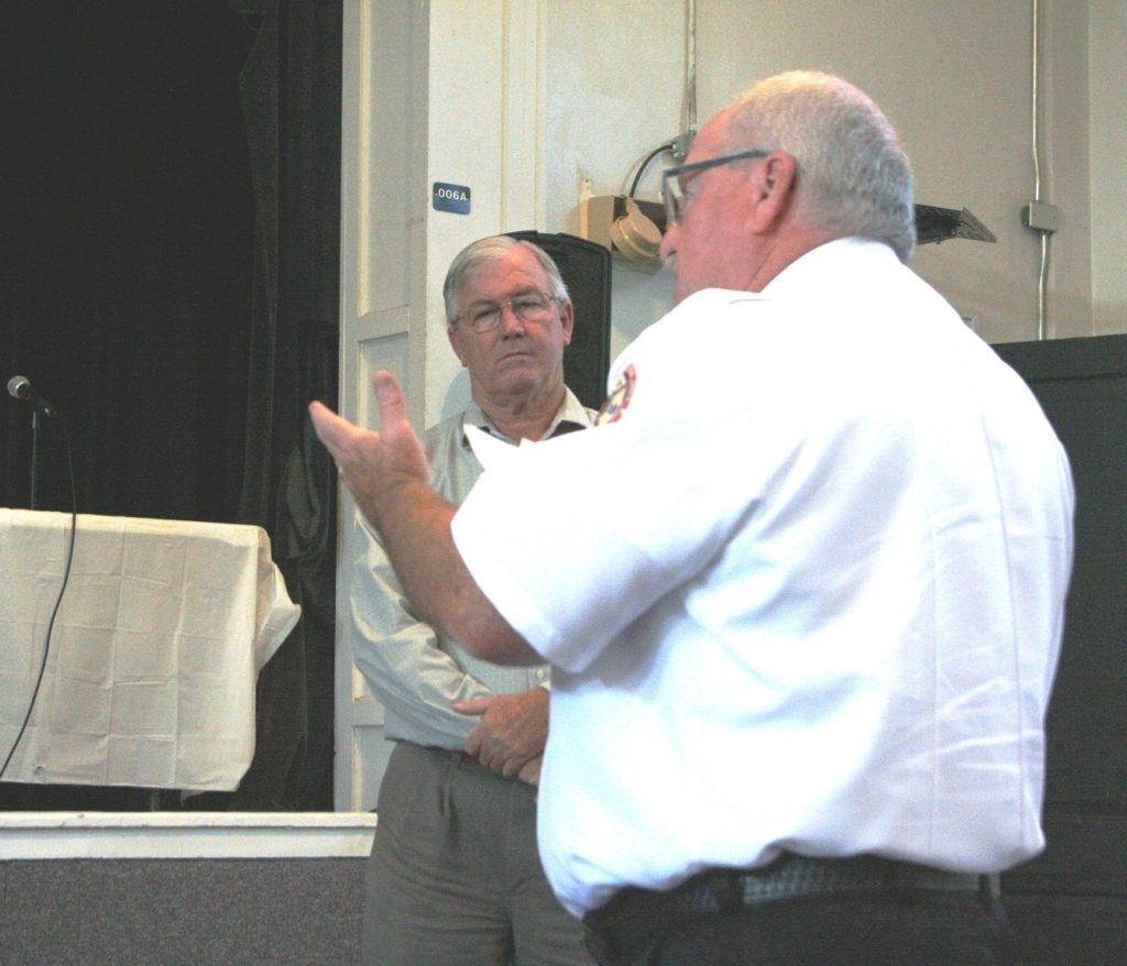 County Public Safety Director Mitch Harrell discusses the EMS assessment as County Coordinator Wilbur Dean listens in the background.