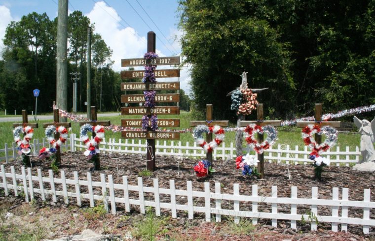 The memorial to five children and their bus driver who died 33 years ago in a school bus accident is fenced and decorated with red, white and blue at the intersection of County Road 32 and 337.