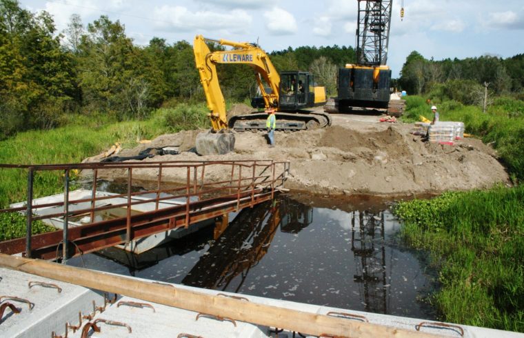 A private bridge construction crew works on the final span of the new Waccasassa River flats bridge near Bronson. The bridge is surrounded on both sides by a massive wetlands area feeding the river with water.