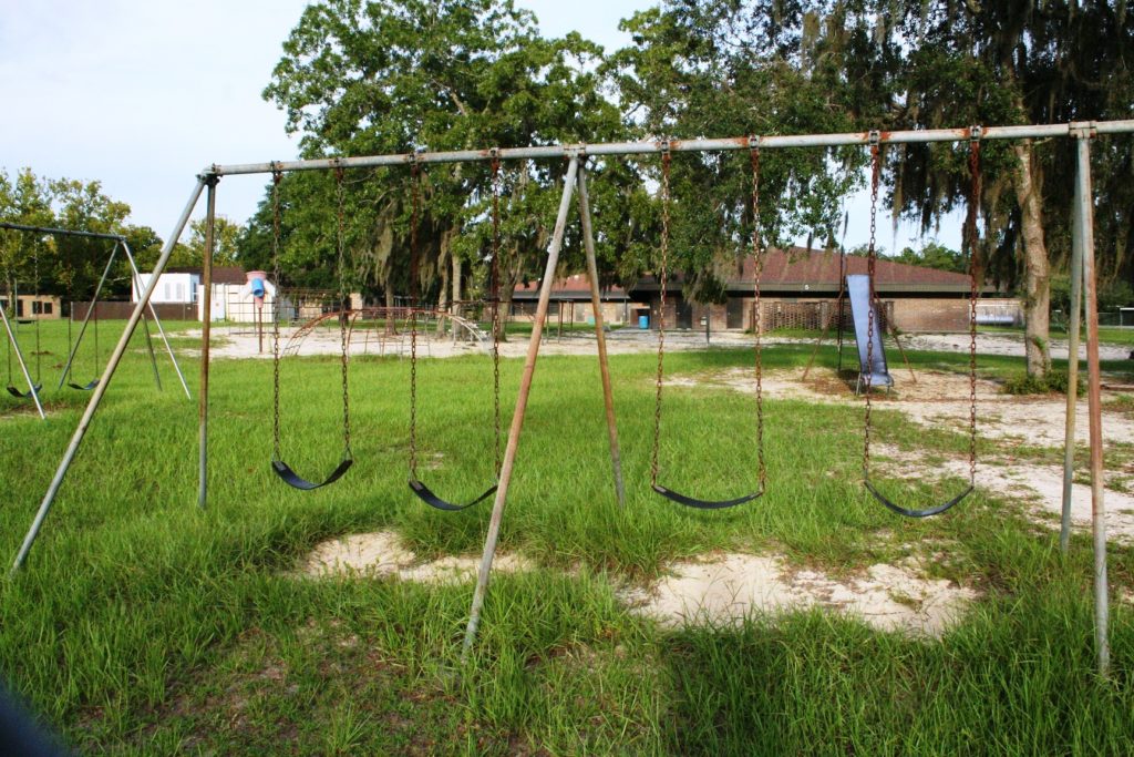 A rusted swing set stands on the playground of Bronson Elementary School.