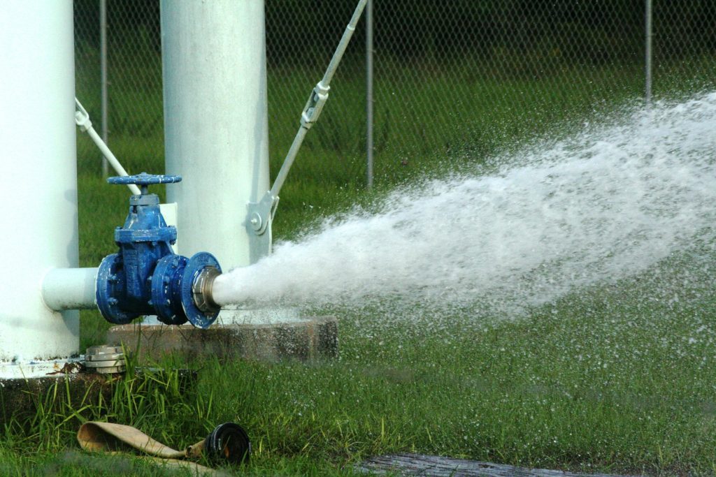 A valve at the bottom of the Bronson water tower releases water as the tower's tank is drained. . The cutoff valve on the tower malfunctioned. The tank had to be drained Friday for repairs on the valve.