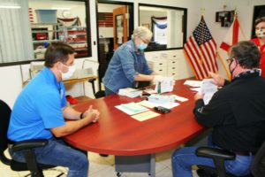 Canvassing board members sort through ballots as they prepare to submit them for insertion into an electronic counter. From the left are County Commission Chairman Matt Brooks, County Commissioner Lilly Rooks and County Judge James T. Browning, who serves as the canvassing board chairman.