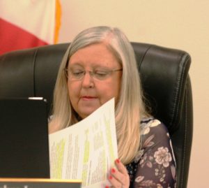 Councilwoman Debra Jones sifts through a résumé as she looks for information about the applicant.