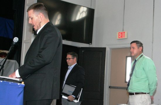 Brian Brooker of the Florida Department of Transportation's Suncoast Connector project speaks to Levy County Commissioners. Ryan Asmus, an FDOT road design project engineer also representing Suncoast, (right) and Jeff Arms of Northern Turnpike Connector project (center) listen to the presentation.