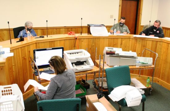 Levy County Supervisor of Elections Tammy Jones (foreground) and fellow Canvassing Board members, County Commissioner Lilly Rooks, County Commission Chairman Matt Brooks and County Judge James T. Browning review and count absentee (mail-in) ballots.