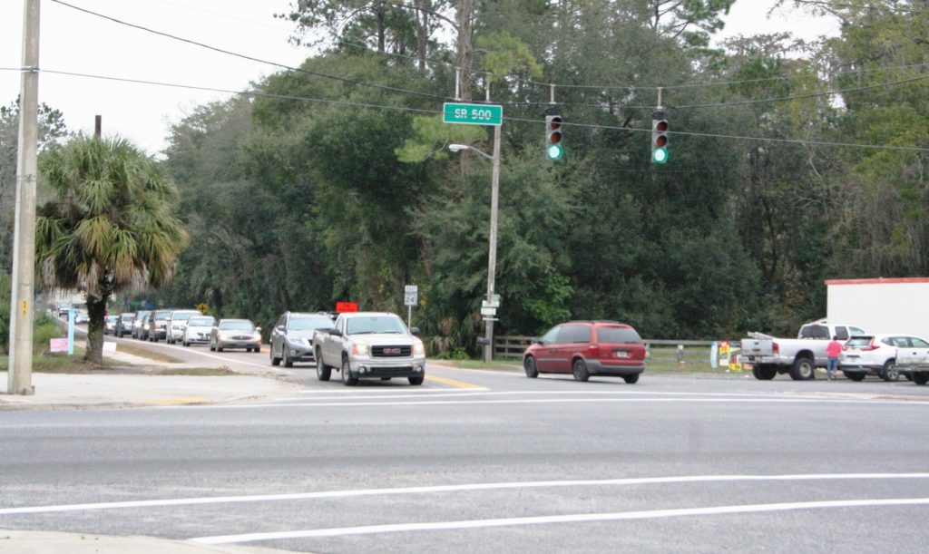 A long line of cars backs up behind the traffic light in Bronson Friday afternoon. The traffic in this photo faces the site of the future gas station/restaurant development on the opposite side of the intersection.