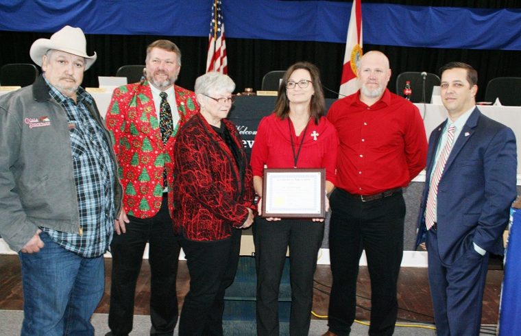 Levy County Tax Collector stands with County Commissioners Mike Joyner, John Meeks, Lilly Rooks, Rock Meeks, and Matt Brooks Tuesday after accepting a certificate plaque honoring her for more than three decades of public service.