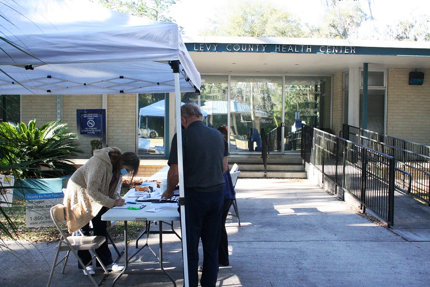 A Levy County couple registers for their COVID-19 vaccination Tuesday afternoon. Sixty people had received the shot by the time this shot was taken at the front of the Levy County Department of Health on Main Street in Bronson.