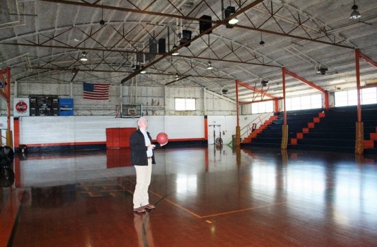 County Coordinator Wilbur Dean, a graduate of Bronson High School, holds a basketball Wednesday as he surveys the old gym he knew well growing up in Bronson.