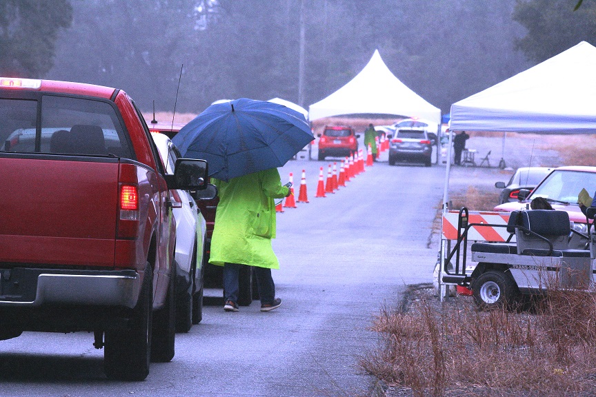 Two vehicles wait their turn at the first drive-thru vaccination event in Williston Friday.