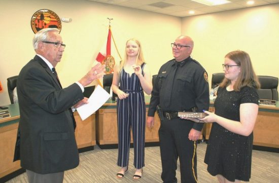 Williston native Jeff Holcomb takes the oath from Mayor Jerry Robinson as his daughters Delaney Holcomb on the left and Courtney Holcomb witness the event at Tuesday's city council meeting.