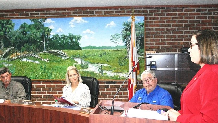 Supervisor of Elections Tammy Jones proposes the school board and county commission adopt identical district lines. Listening are School Board members Brad Etheridge, Ashley Clemenzi, and Chairman Cameron Asbell.