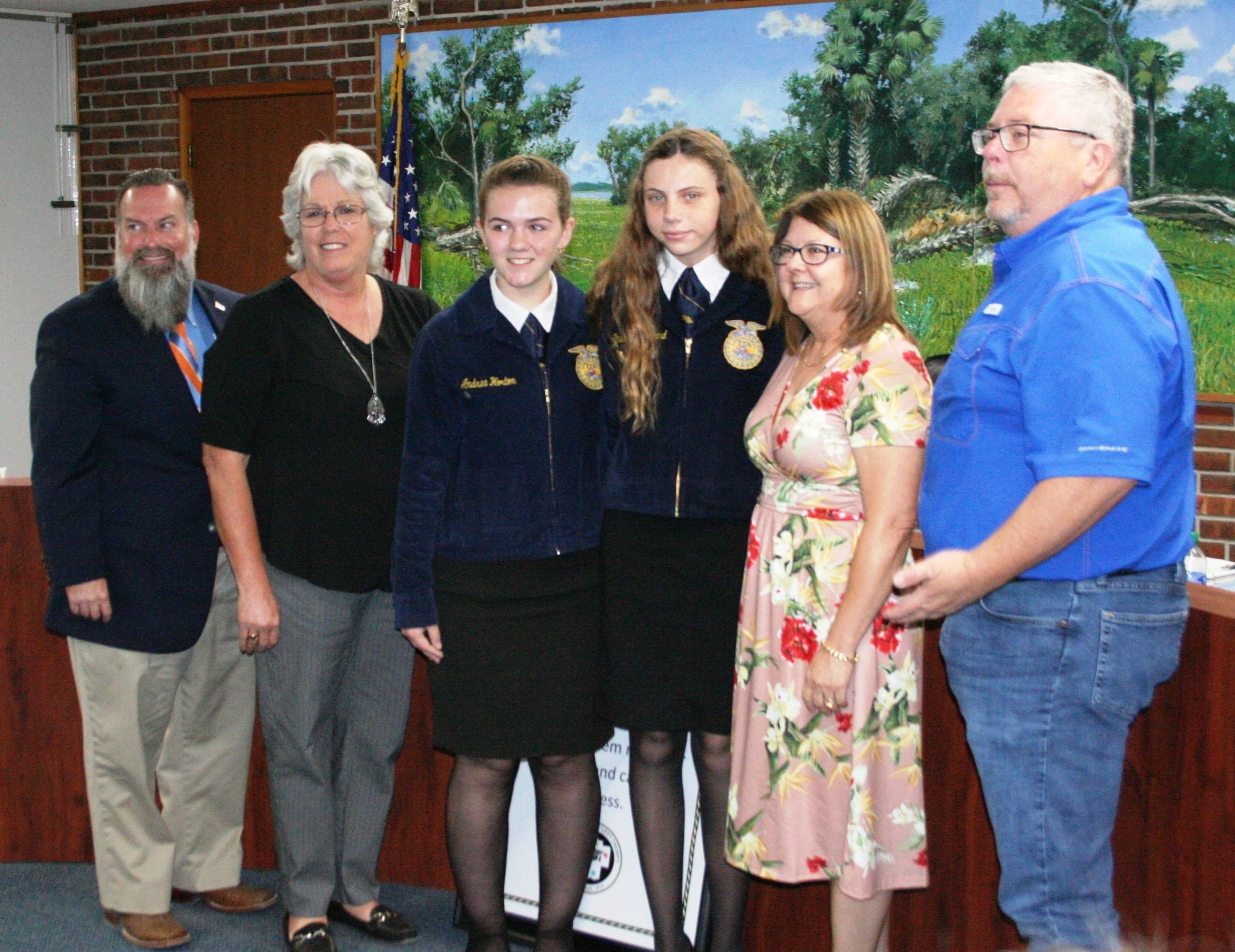 Retiring Bronson Middle High School agriculture instructor Marcia Smith (second from left) is honored by the Levy County School Board meeting Tuesday as the recipient of the Belinda G. Chason Legacy Program Award. Shown from the left, Superintendent Chris Cowart, Smith, BMHS student Andrea Horton, BMHS student Shelby Strickland, District Career and Technical Education Coordinator Carol Jones-Dubois, and School Board Chairman Cameron Asbell.