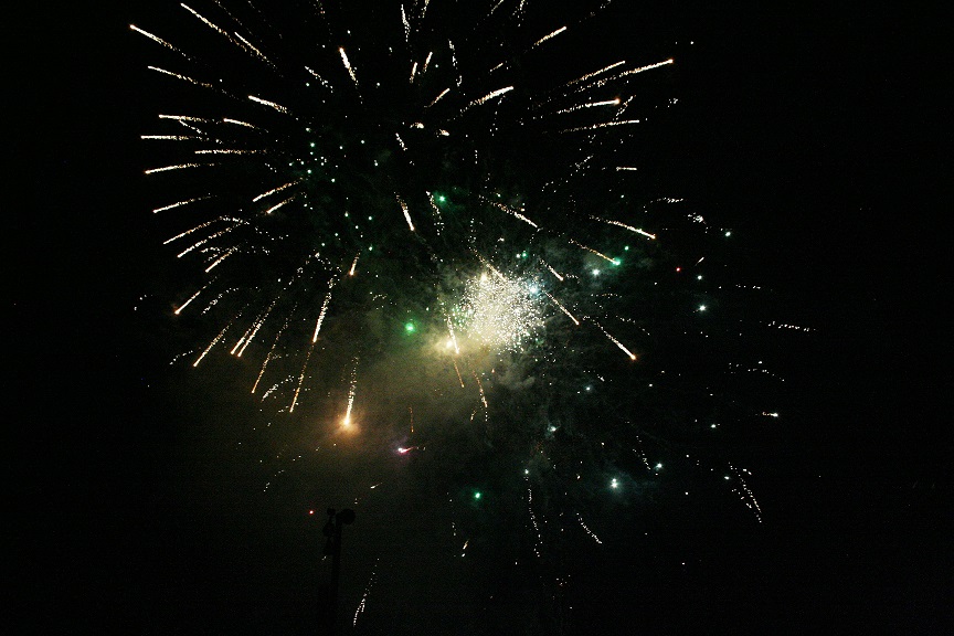 A series of fireworks explode in rapid succession over the horse arena as part of the finale.