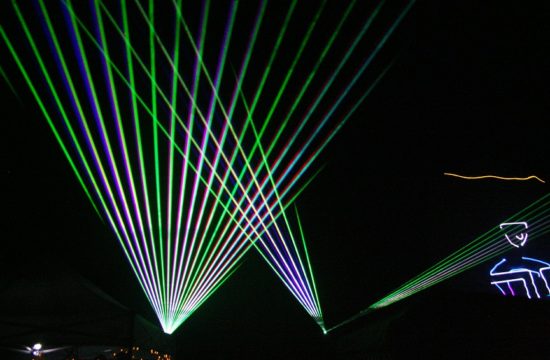 Colorful laser images flash over the crowd.