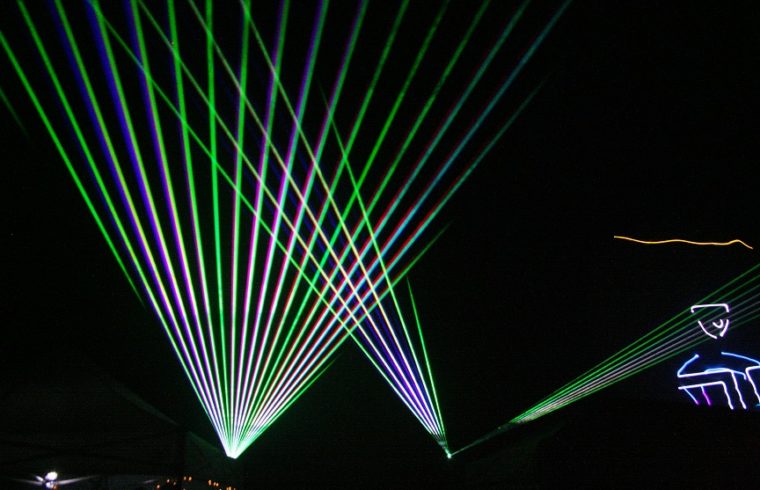 Colorful laser images flash over the crowd.