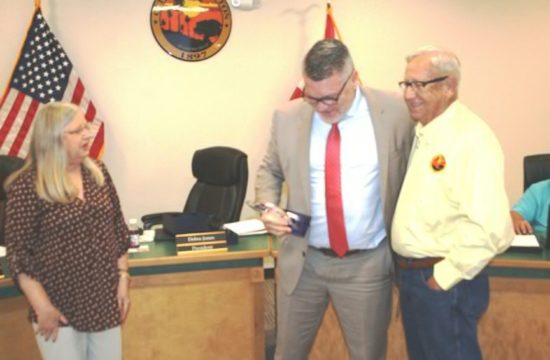 Fred Koberlein jokes with Mayor Jerry Robinson as Council President Debra Jones looks on. Koberlein is holding the desktop plaque given to him by Jones.