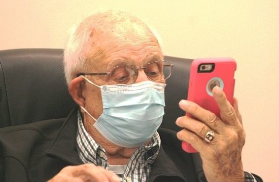 Councilman Elihu Ross talks to budget analyst Stephen Bloom via speakerphone during Tuesday's meeting concerning what options the city might exercise to balance its budget.