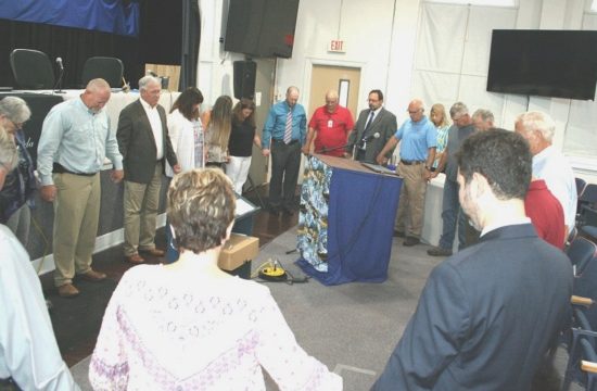 Levy County Commissioners, staff, and members of the public gather in a prayer circle before the start of Tuesday's board meeting to pray for hospitalized County Commissioner Mike Joyner and others in the community who are sick or have lost loved ones. Joyner missed Tuesday's meeting. Commission Chairman John Meeks would say only that he is hospitalized.