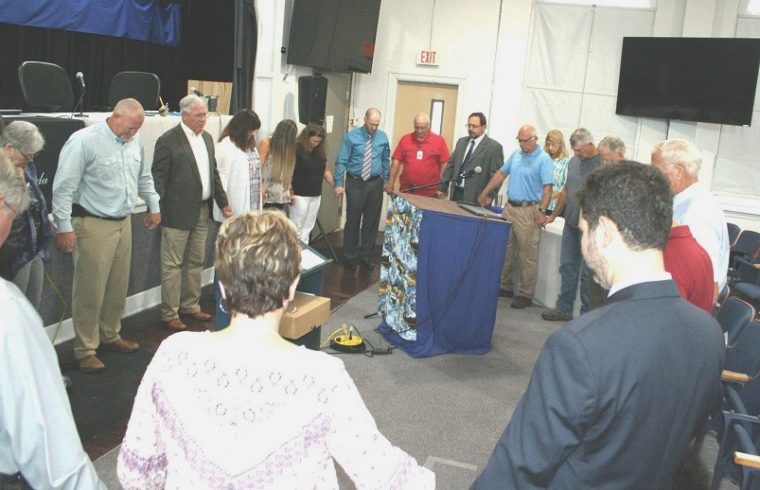 Levy County Commissioners, staff, and members of the public gather in a prayer circle before the start of Tuesday's board meeting to pray for hospitalized County Commissioner Mike Joyner and others in the community who are sick or have lost loved ones. Joyner missed Tuesday's meeting. Commission Chairman John Meeks would say only that he is hospitalized.