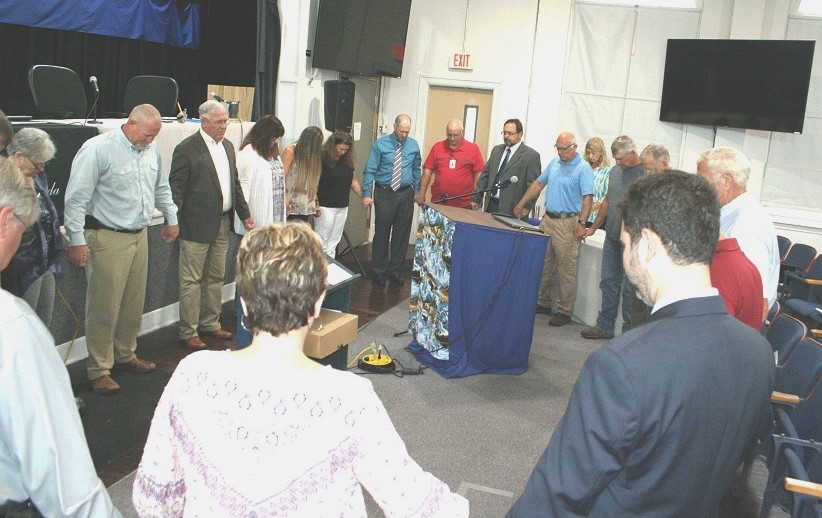 Levy County Commissioners, staff, and members of the public gather in a prayer circle before the start of Tuesday's board meeting to pray for hospitalized County Commissioner Mike Joyner and others in the community who are sick or have lost loved ones. Joyner missed Tuesday's meeting. Commission Chairman John Meeks would say only that he is hospitalized.