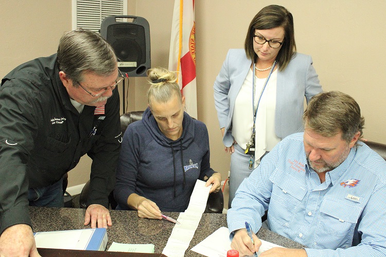 County Judge James T. Browning, Bronson Deputy Clerk Wendy Maragh, Supervisor of Elections Tammy Jones and County Commission chairman John Meeks review election results before announcing them. Browning, Maragh, and Meeks were the canvassing board.