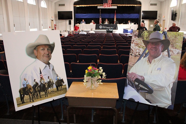 Levy County Commissioners paid a final tribute to the late Levy County Commissioner Mike Joyner and the late Property Appraiser Osborn Barker. Both passed away. Their photos were set up at the entrance to the county commissioner meeting room Tuesday