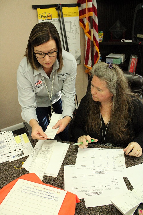 Supervisor of Elections Tammy Jones works with Town Manager Susan Beaudet Friday after the vote was certified.