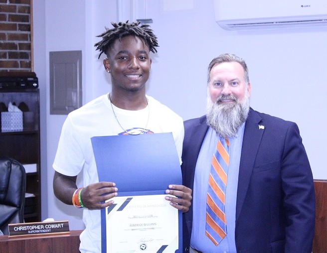 Bronson Middle High School student Kendrick Williams is honored by School Superintendent Chris Cowart for his role in coming to the aid of a player from another school during a football game.