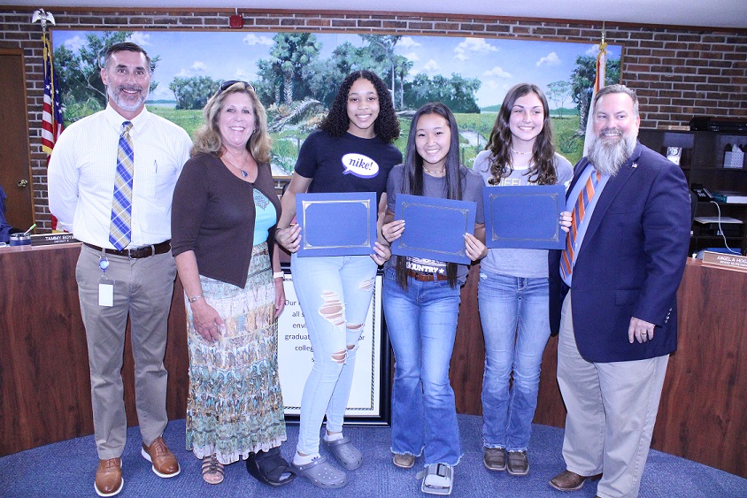 Three Chiefland Middle High School students are recognized for helping a student having a seizure during a volleyball practice. From the left are CMHS Principal Matthew McLelland, School Board member Paige Brooks, students Layla Buie, Allison Alvord, and Dana Hinkle and School Superintendent Chris Cowart.