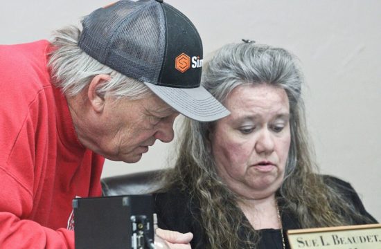 Bronson Fire Chief Dennis Russell confers with Town Manager Susan Beaudet before the Bronson Town Council meeting Monday.