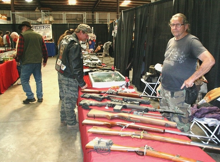 Customers attending the February 2021 gun show in Williston browse through the selection of weapons.