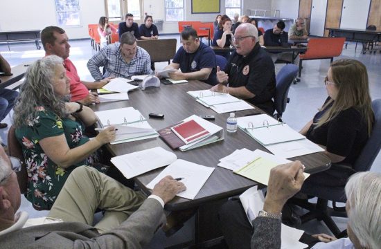 Levy County Department of Public Safety Director Mitch Harrell on the right (dark shirt) explains the union contract. Pictured around the table starting at the lower left are County Coordinator Wilbur Dean, County Human Resources Director Jacqueline Martin, IAFF Union President Ryan Tietjen, union negotiators Jimmy Willis, Jr. and Shawn Holcomb, Harrell, Assistant Public Safety Director Alesha Rinaudo and on the lower right, county labor attorney Wayne Helsby.