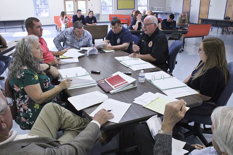 Levy County Department of Public Safety Director Mitch Harrell on the right (dark shirt) explains the union contract. Pictured around the table starting at the lower left are County Coordinator Wilbur Dean, County Human Resources Director Jacqueline Martin, IAFF Union President Ryan Tietjen, union negotiators Jimmy Willis, Jr. and Shawn Holcomb, Harrell, Assistant Public Safety Director Alesha Rinaudo and on the lower right, county labor attorney Wayne Helsby.