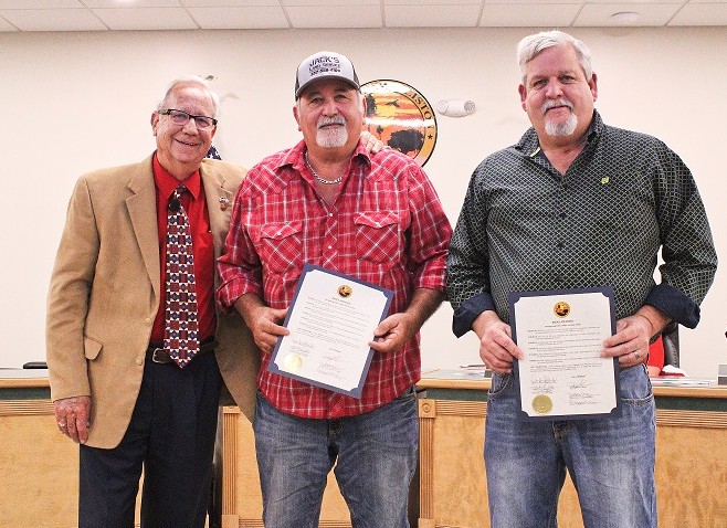 Mayor Jerry Robinson presents certificates to businessmen Jack Penney and Eddie Hodge for voluntarily mowing the hospital grounds.