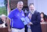 School Superintendent Chris Cowart presents Bronson Middle High School Dean John Miller with a certificate for coming to the aid of a football player from another school.