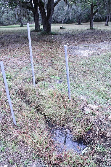 Stormwater from Tuesday's rain fills a School Street drainage culvert and flows onto private property.