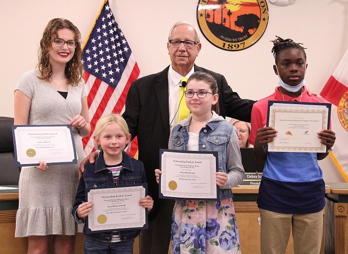 Williston Mayor Jerry Robinson presents Students of the Month Kierra Andrews, Kyan Raelynn Smith, Alivia Westbrook, and Kyrin Penny with their certificates.