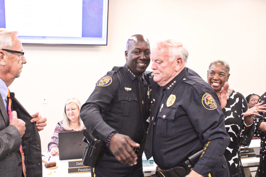 Incoming Police Chief Mike Rolls and Police Chief Dennis Strow share a man hug as the ceremonies come to a close.