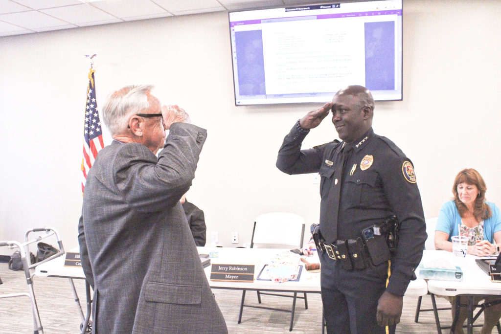 Mayor Jerry Robinson shares a salute with incoming Police Chief Mike Rolls.